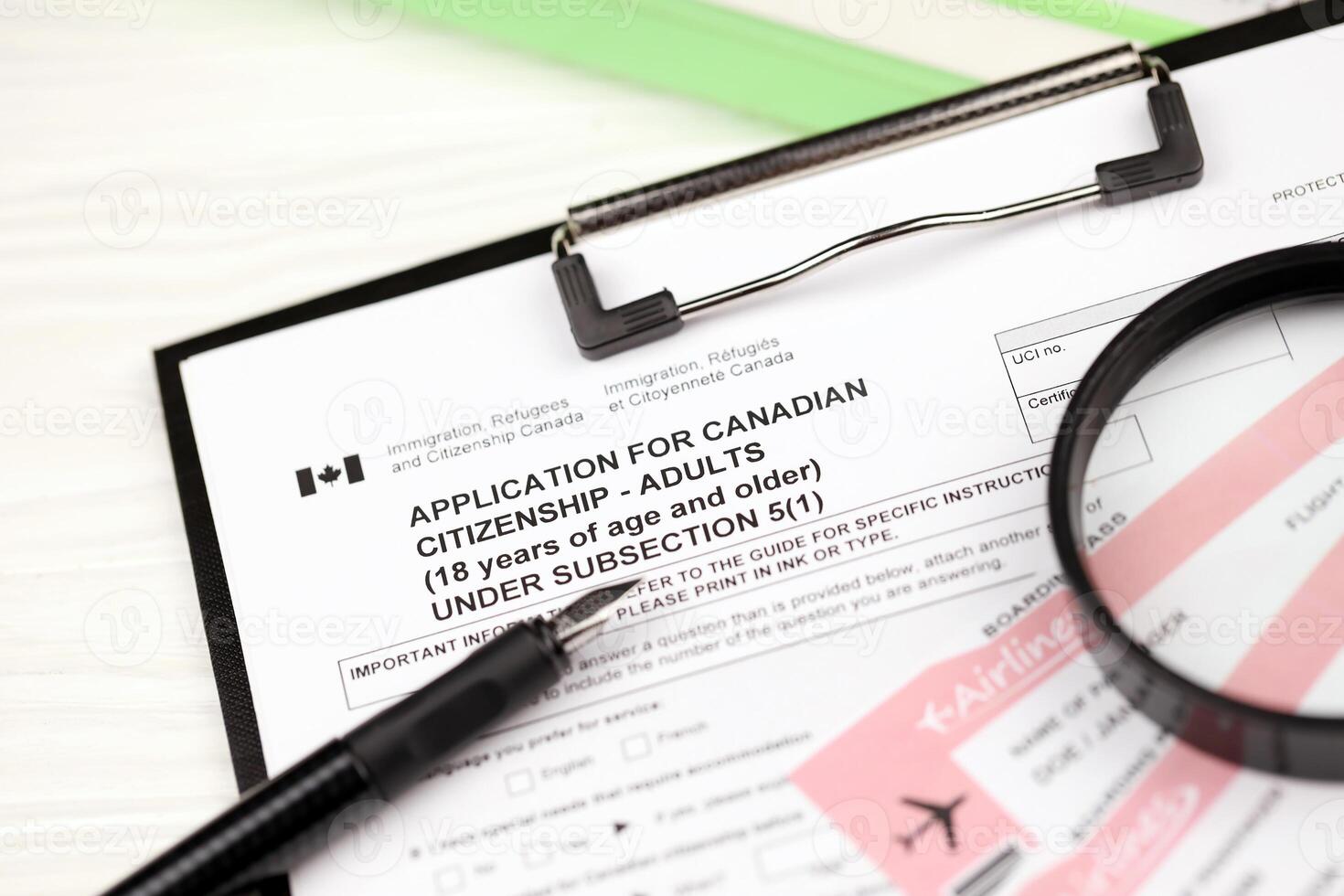 Application for Canadian citizenship for adults on A4 tablet lies on office table with pen and magnifying glass photo