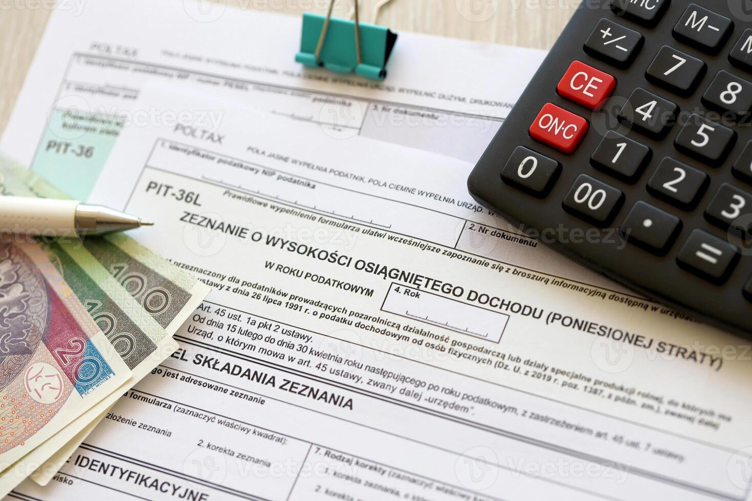 Declaration of the amount of earned income or incurred loss, PIT-36 and PIT-36L tax forms on accountant table with pen and polish zloty money bills photo