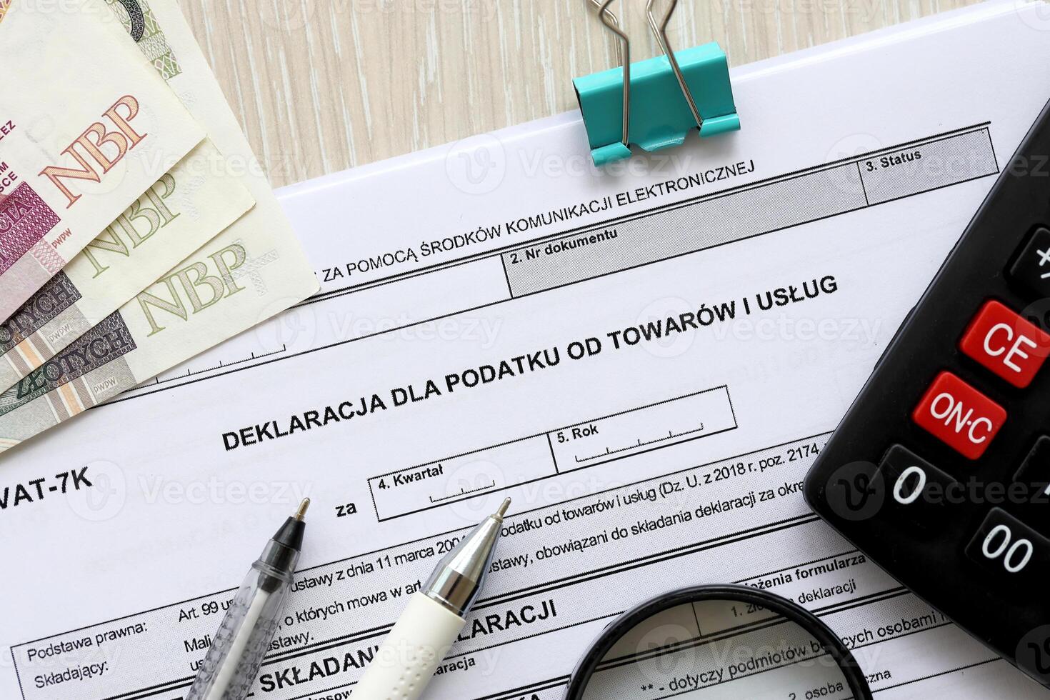 Declaration for tax on goods and services VAT-7K form on accountant table with pen and polish zloty money bills photo