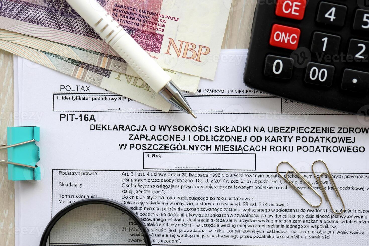 Declaration of amount of health insurance contributions paid and deducted from tax card in individual months of tax year, PIT-16A form on accountant table with pen and polish zloty money photo