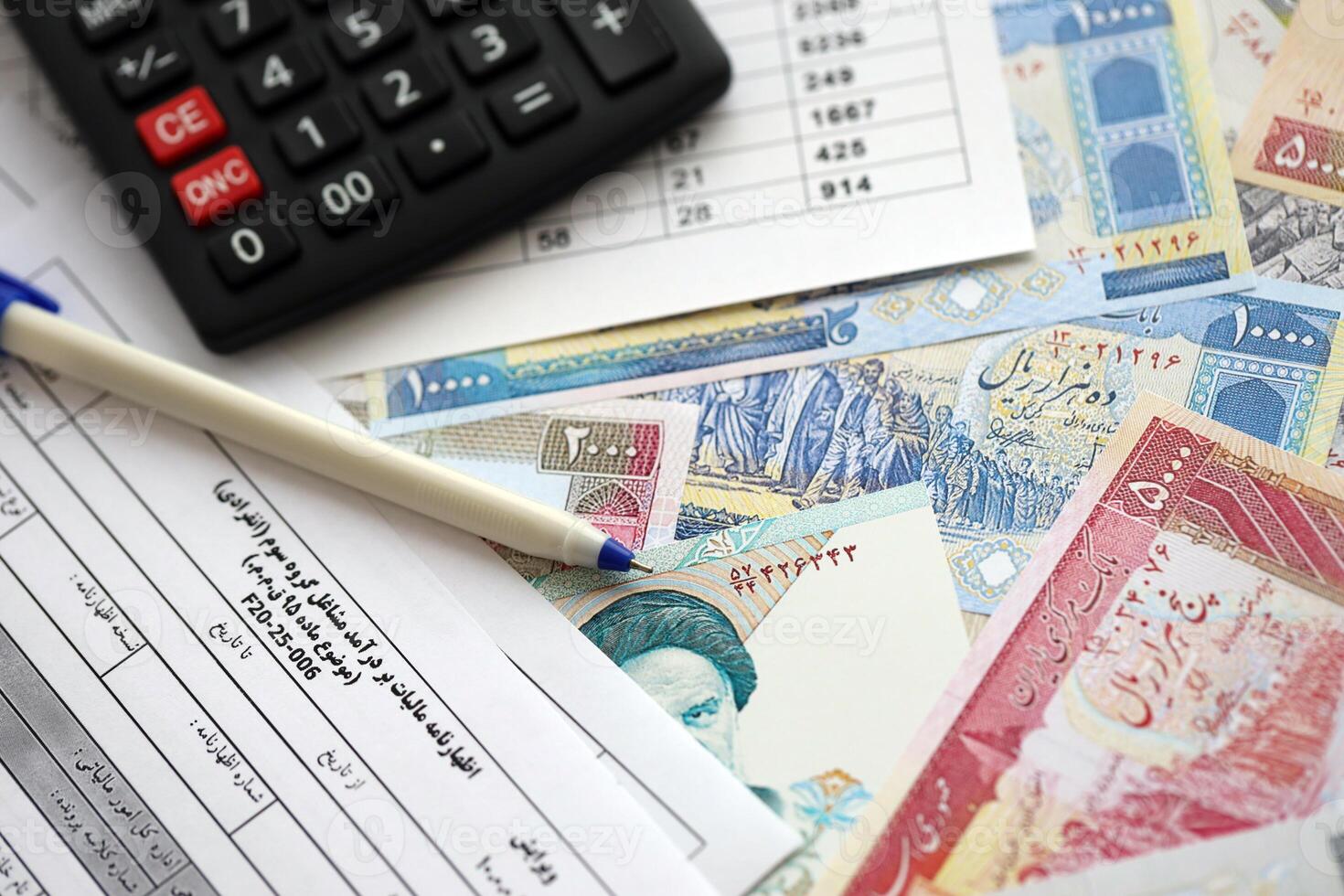 Iranian annual income tax return form F20-25-006 ready to fill on table with pen, calculator and iranian money photo