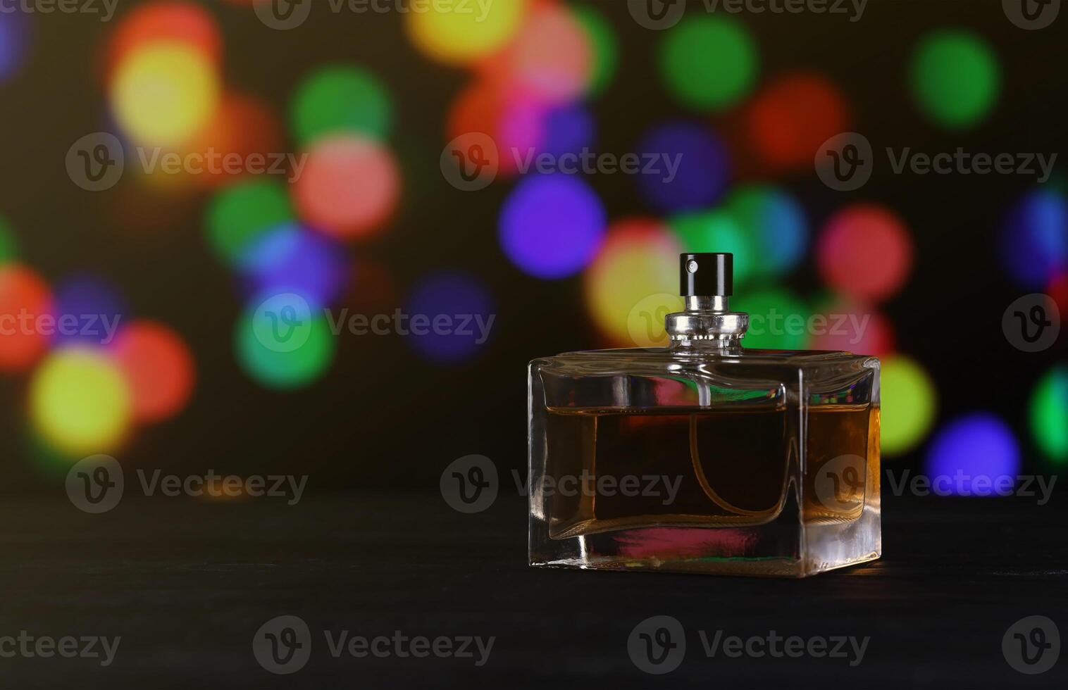 Women fragrance perfume bottle on dark festive background close up. Unnamed blank sprayer bottle of perfume photo
