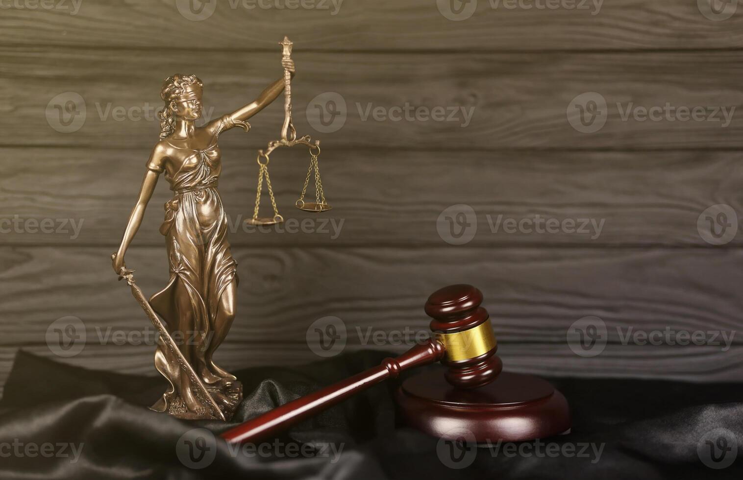 The Statue of Justice - lady justice or justitia the Roman goddess of Justice. Statue on brown book with judge gavel. Concept of judicial trial, courtroom process and lawyers work photo