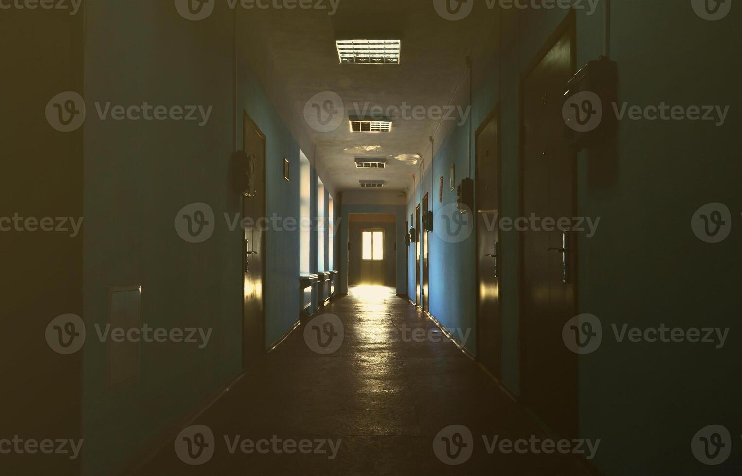 The gloomy corridor of a neglected public building. Public space in a poor residential high-rise building photo