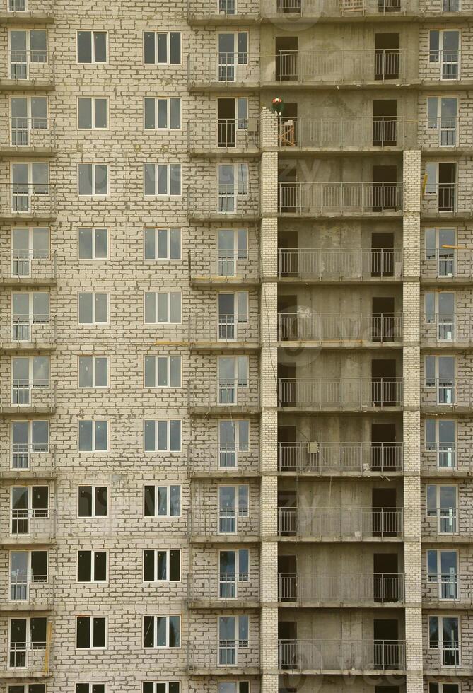 Textured pattern of a russian whitestone residential house building wall with many windows and balcony under construction photo