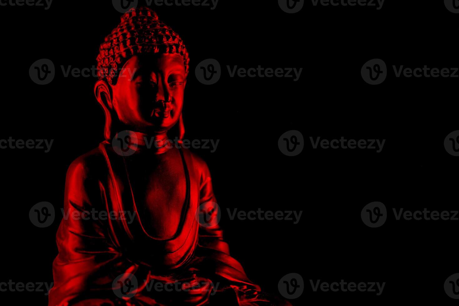 Buddha Purnima and Vesak day concept, Red Buddha statue with low key light against deep black background photo