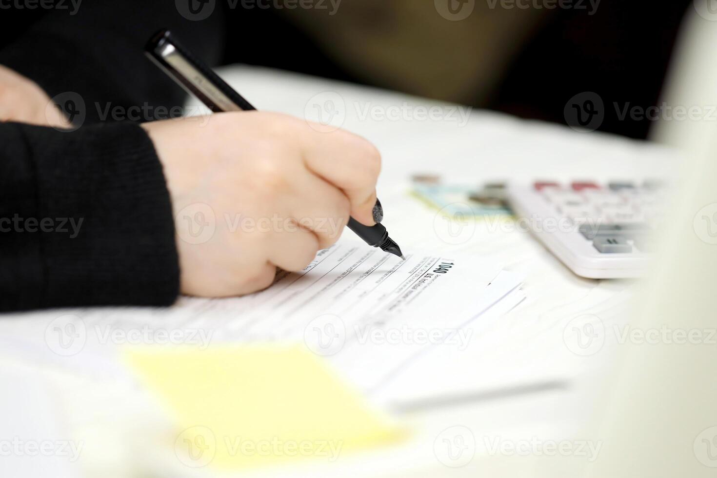 Accountant fill American tax form 1040 Individual income tax return in end of tax period. Taxation and paperwork routine photo