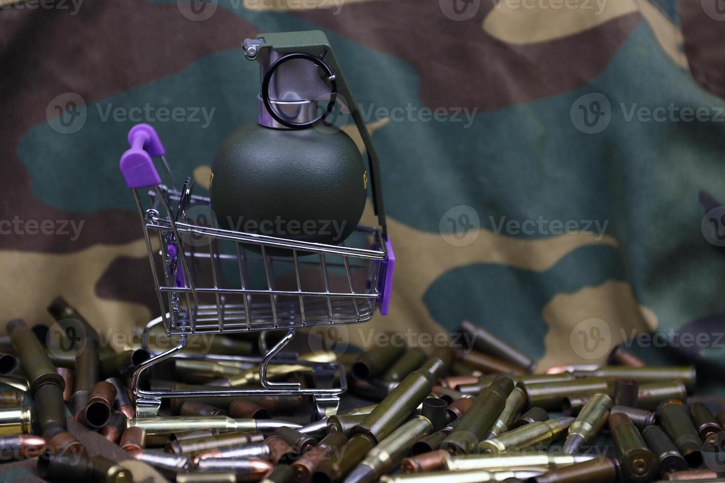 Rifle cartridges in small shopping cart. Big caliber ammo cartridges and hand grenades with a small shopping basket photo