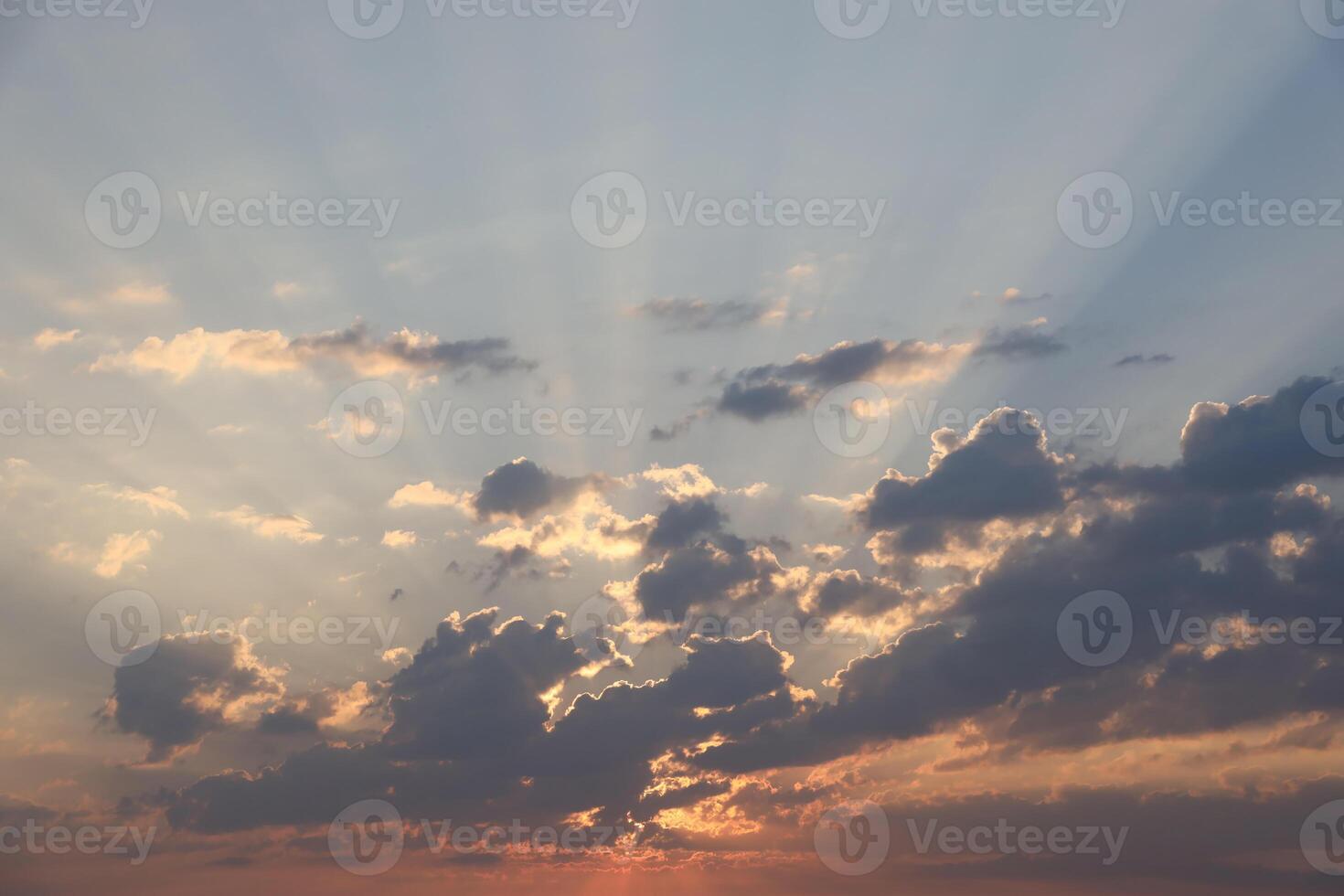 Beautiful sunrise with warm orange sunlight and beams through blue sky photo