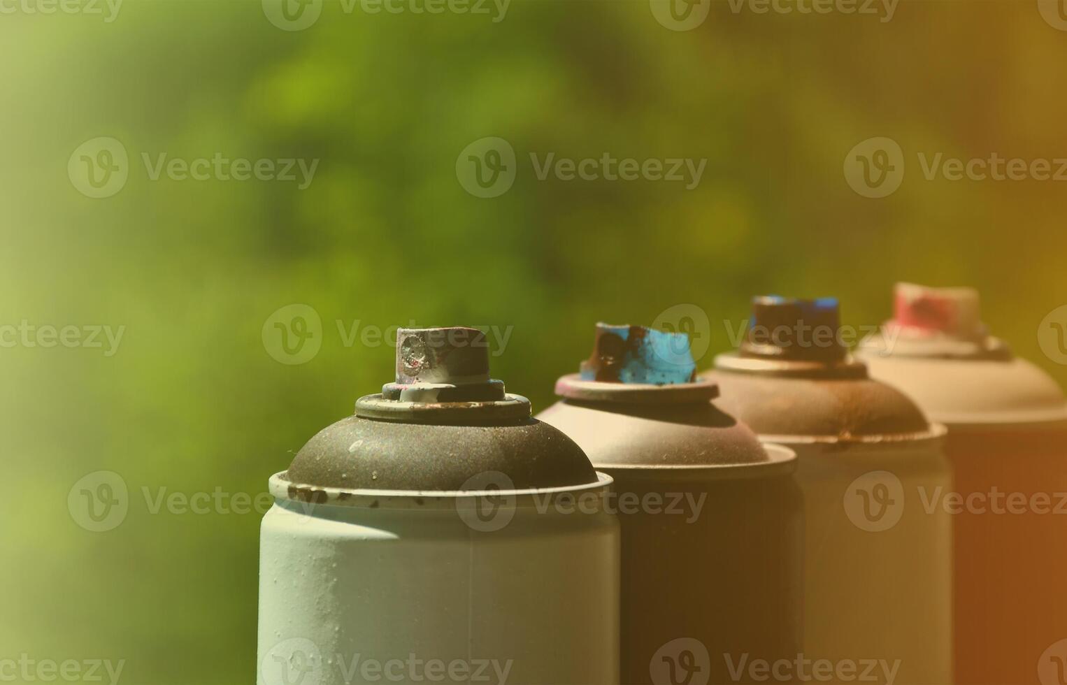 A few used aerosol paint sprayers lie on the windowsill in the workshop of a graffiti artist. The concept of street art and illegal drawing on the walls. Youth hobby photo