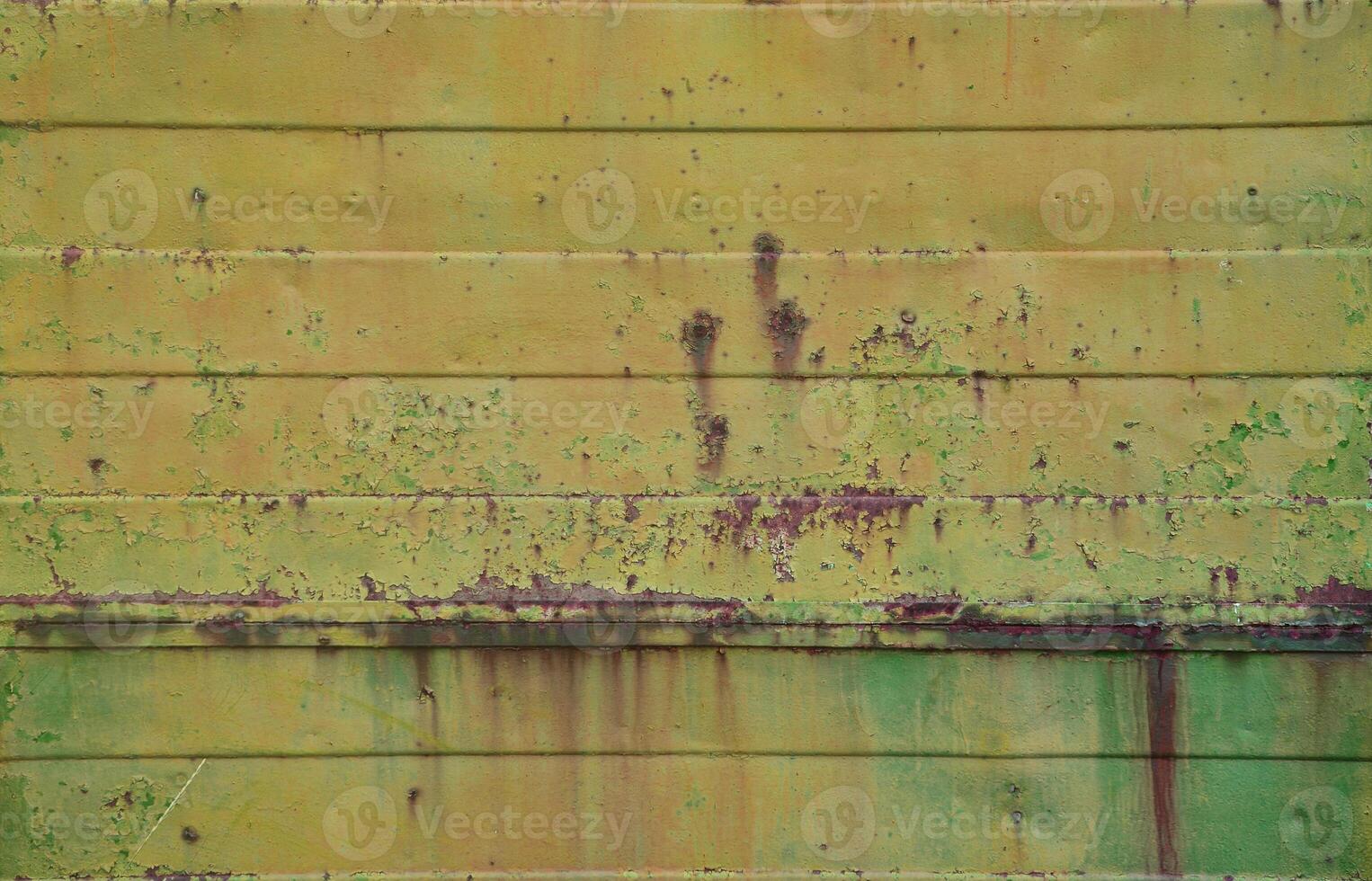 Texture of an old yellow metal wall with significant damage from exposure to unfavorable weather conditions and dampness photo