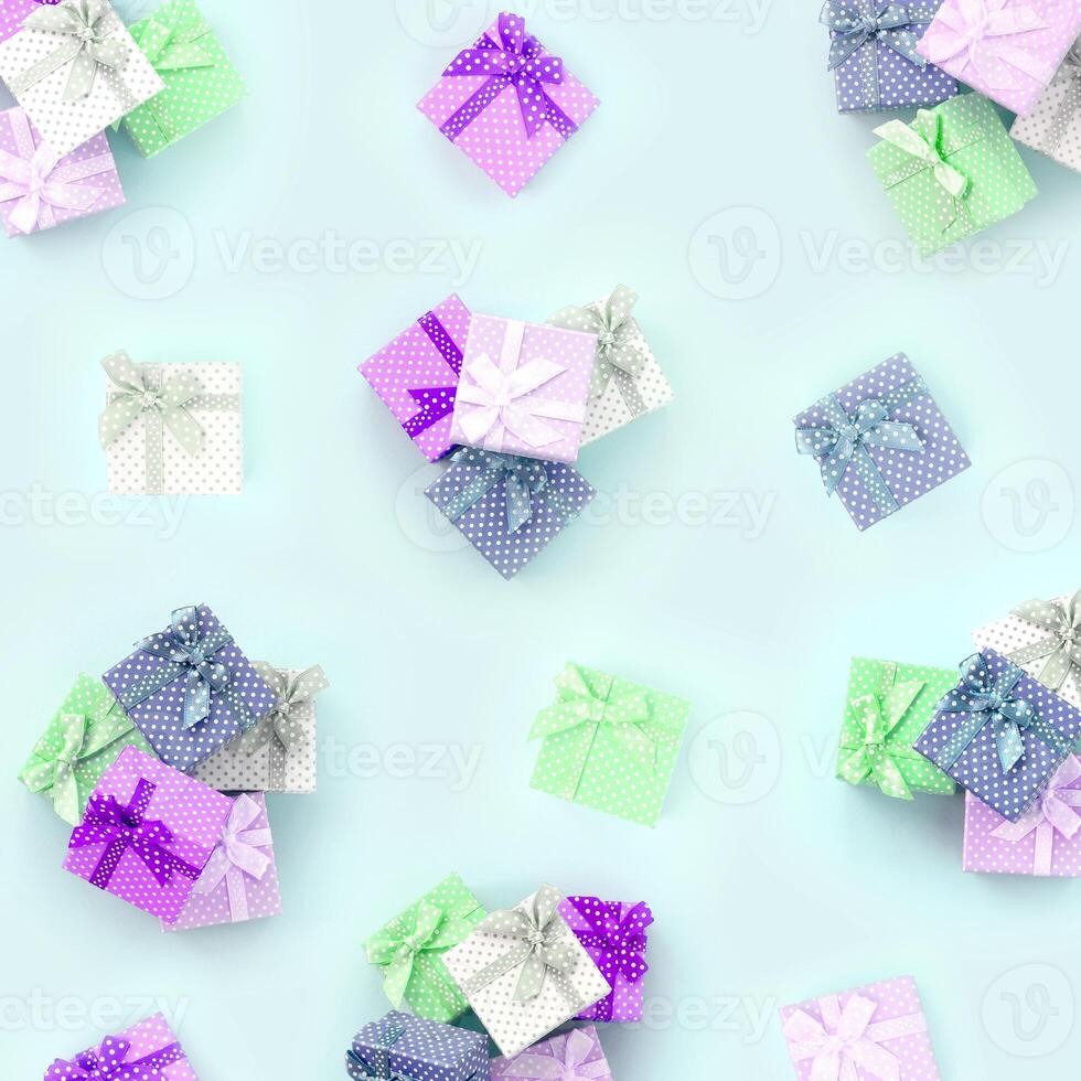 Piles of a small colored gift boxes with ribbons lies on a violet background. Minimalism flat lay top view pattern photo