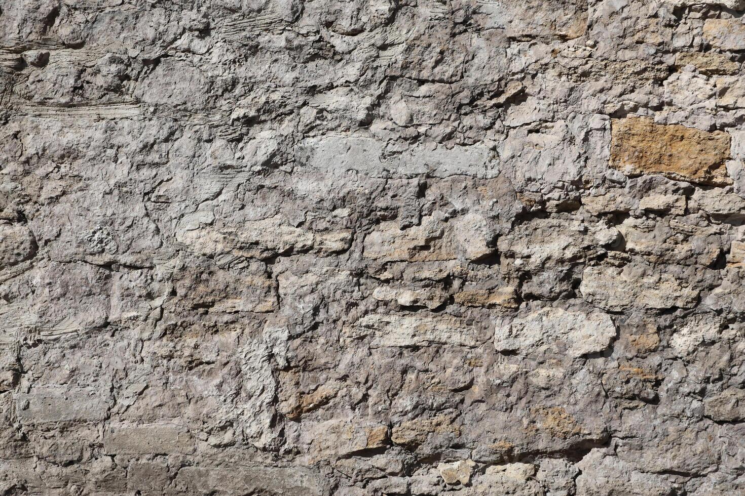 Very old brick stone wall of castle or fortress of 18th century. Full frame wall with obsolete dirty and cracked bricks photo