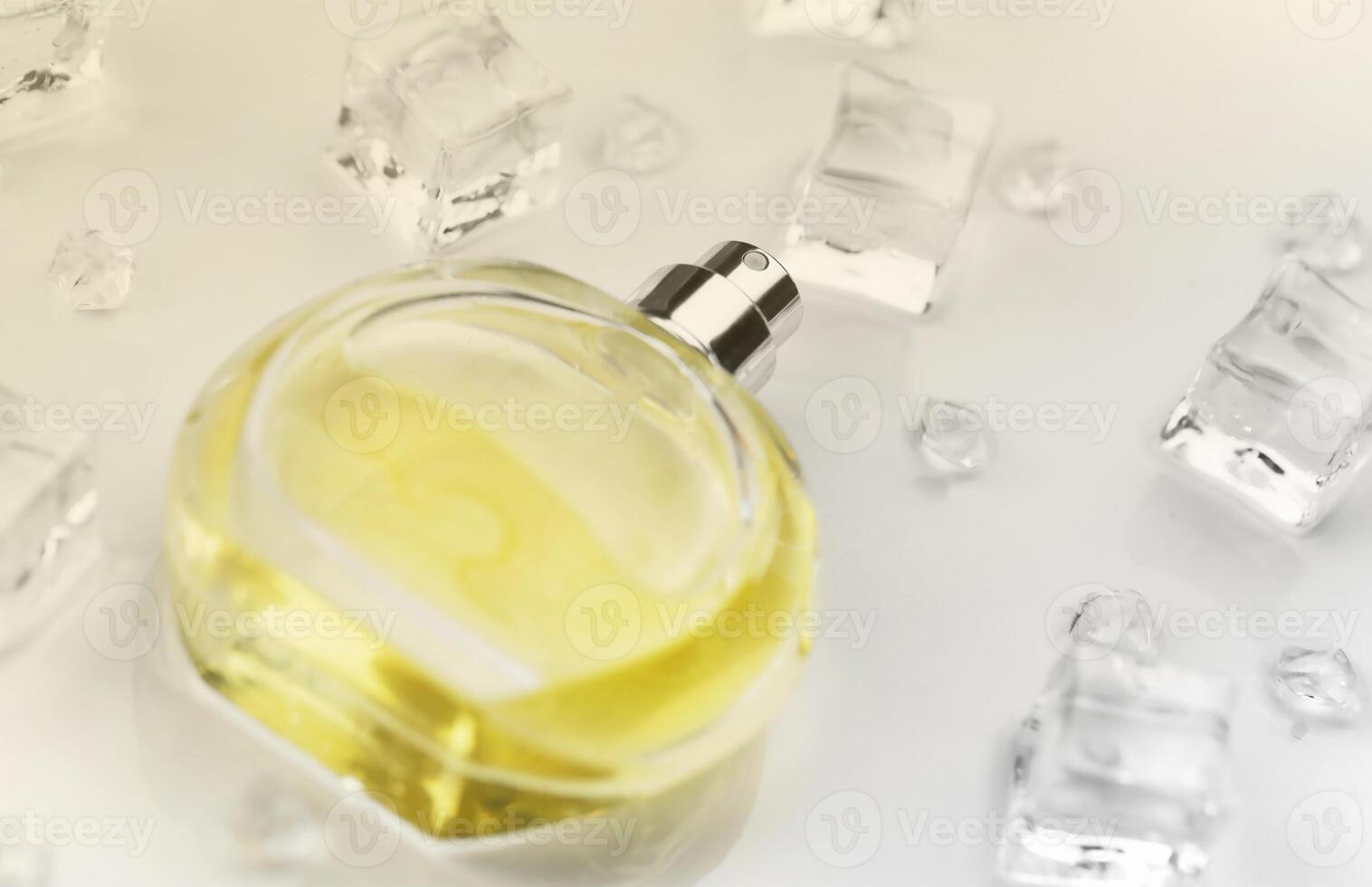 Female perfume yellow bottle, Objective photograph of perfume bottle in ice cubes and water on white table. View from above. Mockup product photo, concept of freshness photo
