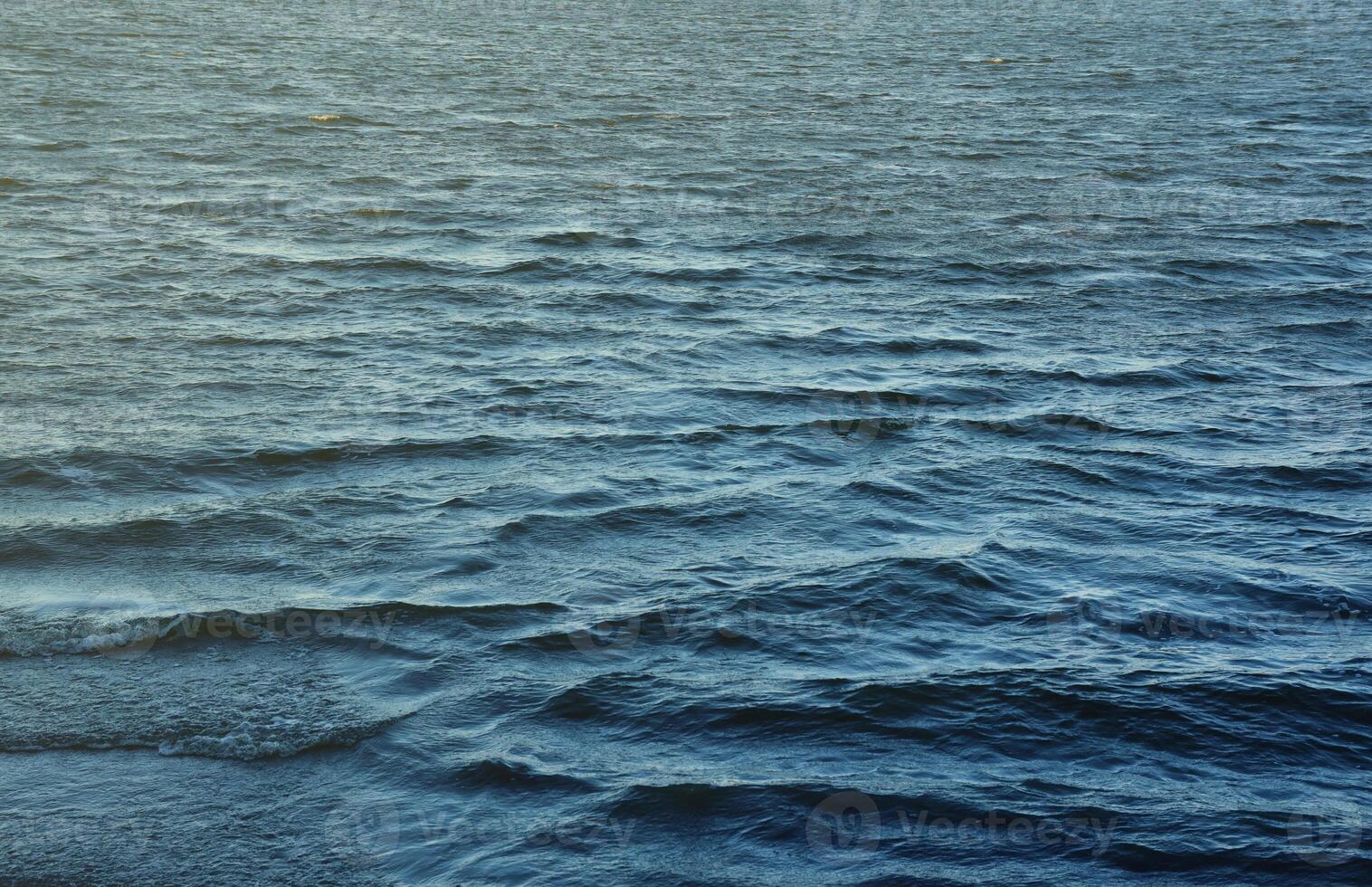 The raging waters of the river. Top view background texture of the raging elements. White foam on blue waving water photo