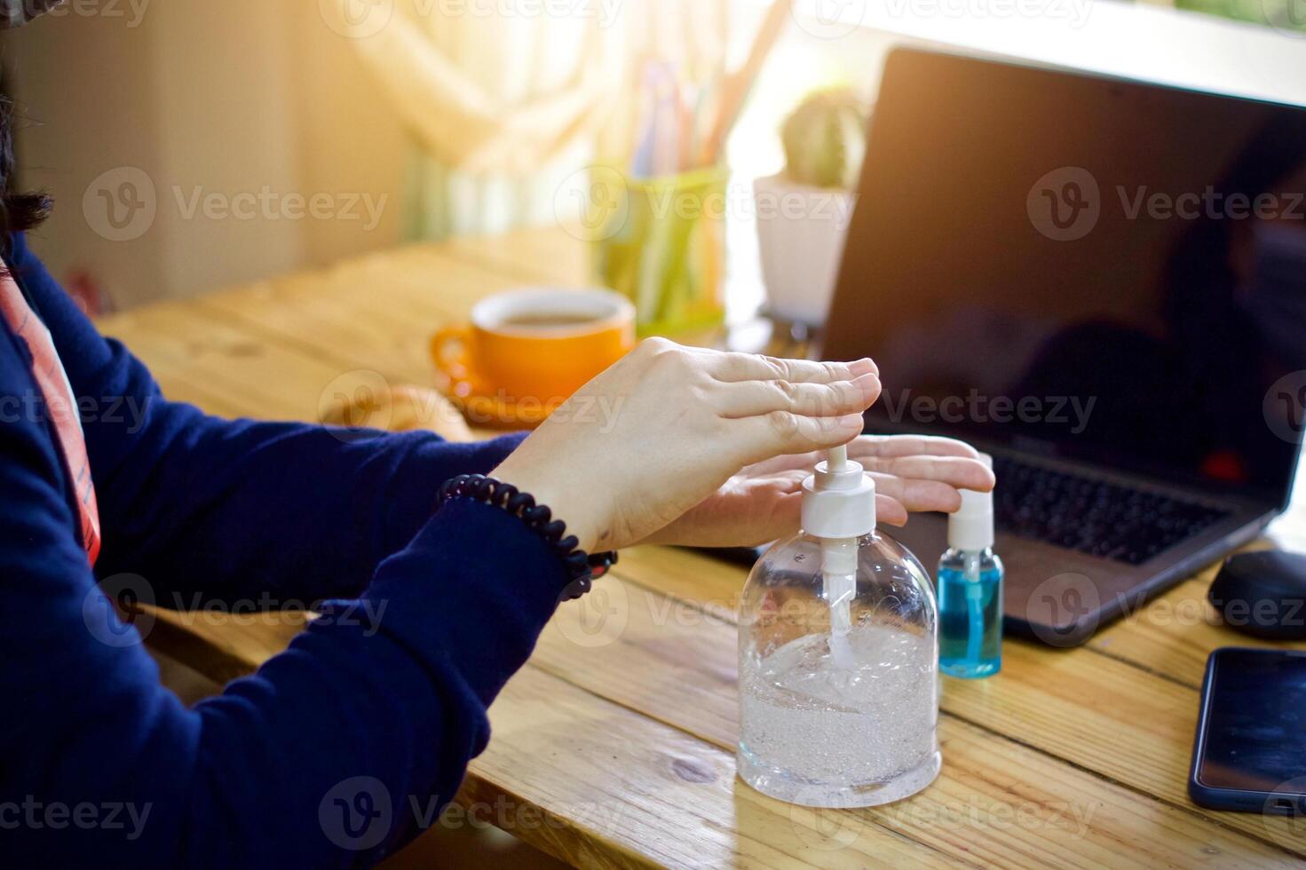 Women using laptop working and clean hands with alcohol drink coffee cup hot at home photo