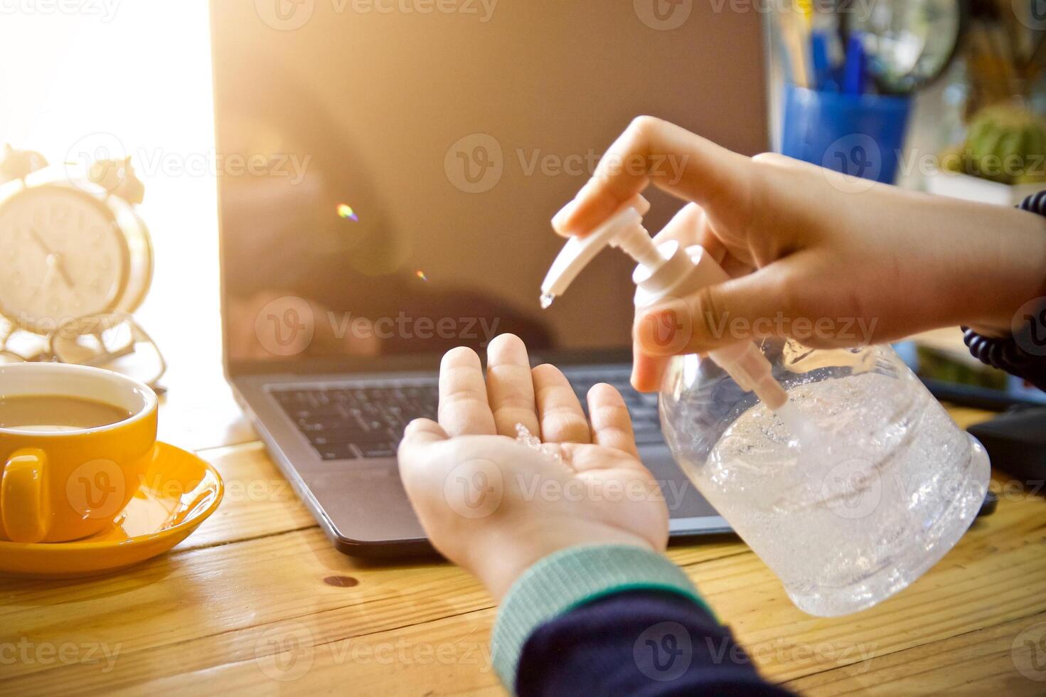 Women using laptop working and clean hands with alcohol drink coffee cup hot at home photo