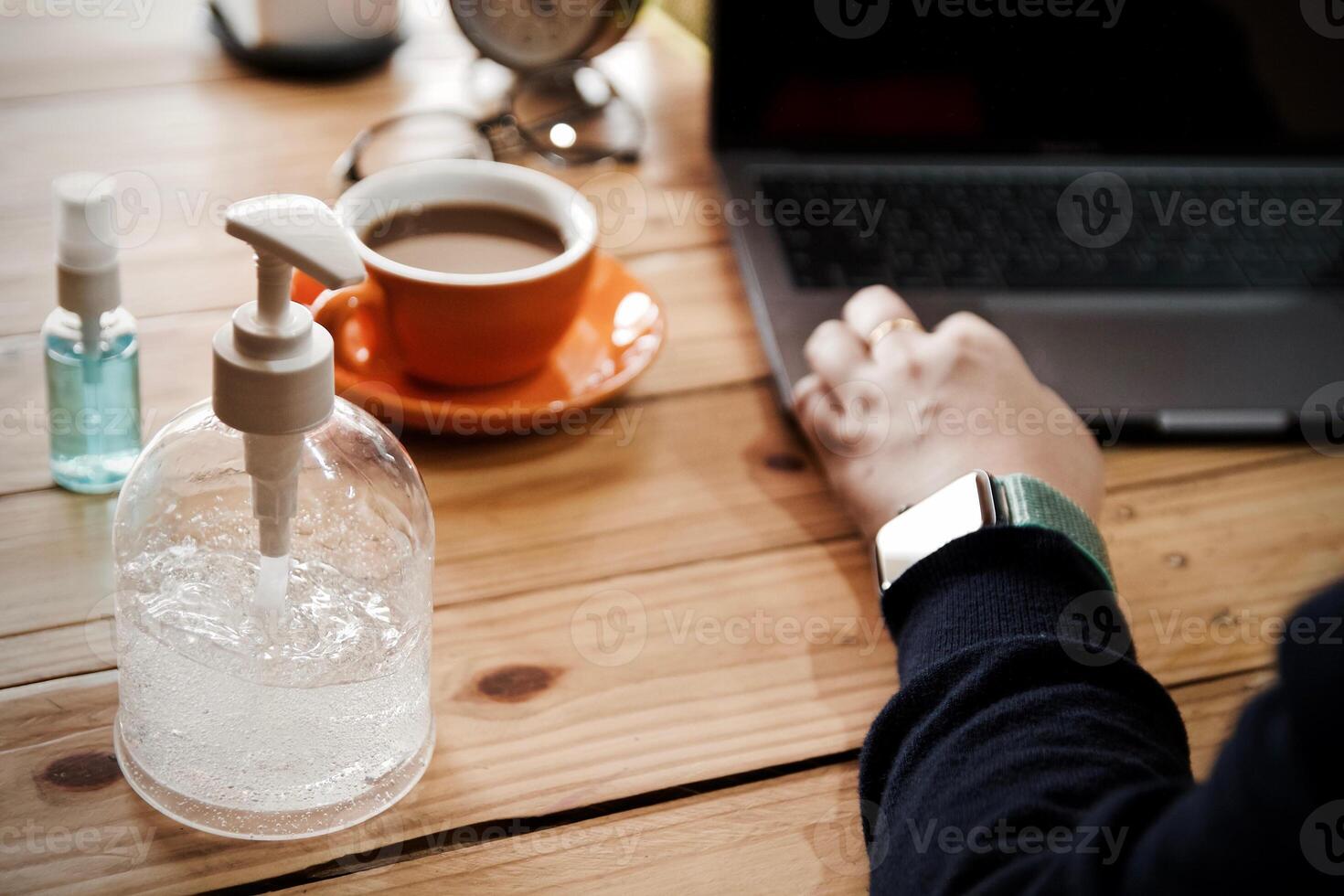 Women using laptop working and clean hands with alcohol drink coffee cup hot at home photo