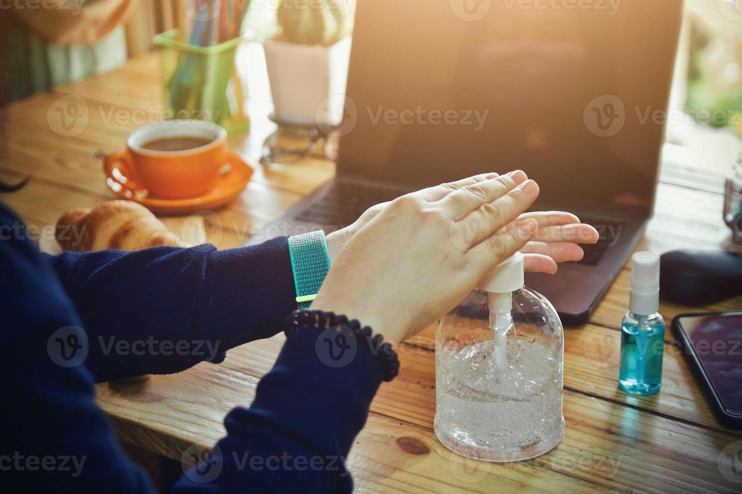 Women using laptop working clean hands with alcohol and drink coffee cup hot in the morning photo