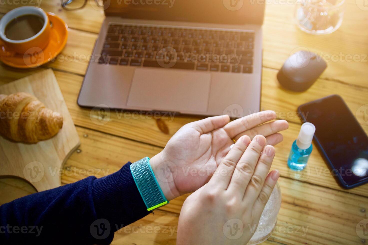 Women using laptop working clean hands with alcohol and drink coffee cup hot in the morning photo