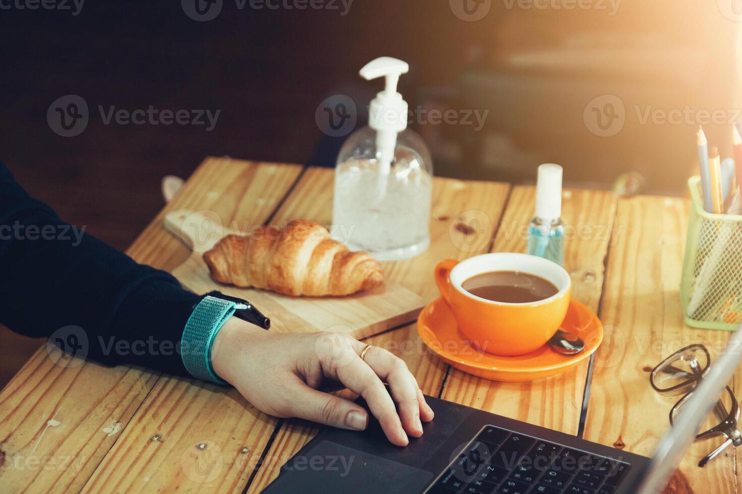 Women using laptop working and clean hands with alcohol drink coffee cup hot at home photo