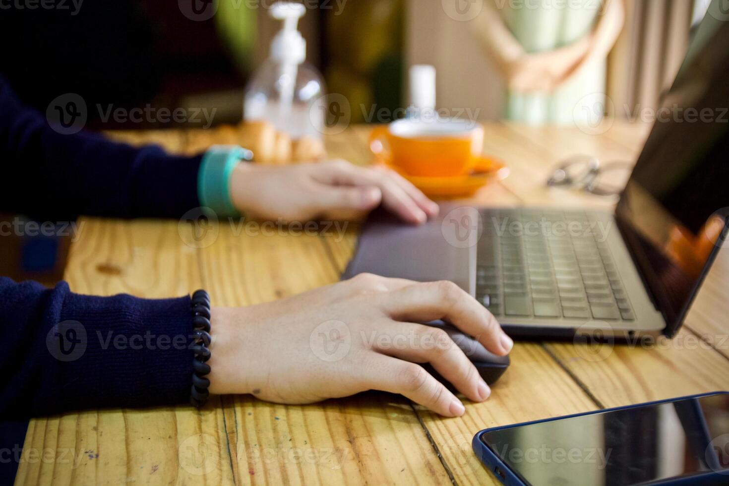 mujer utilizando ordenador portátil trabajando y limpiar manos con alcohol bebida café taza caliente a hogar foto