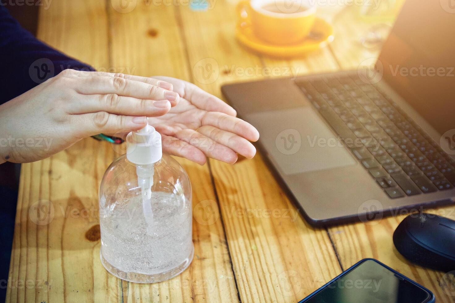 Women using laptop working and clean hands with alcohol drink coffee cup hot at home photo
