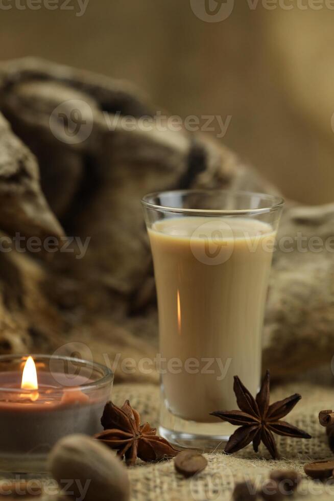 Glass of irish cream liqueur with spice. Cloth background with copy space photo