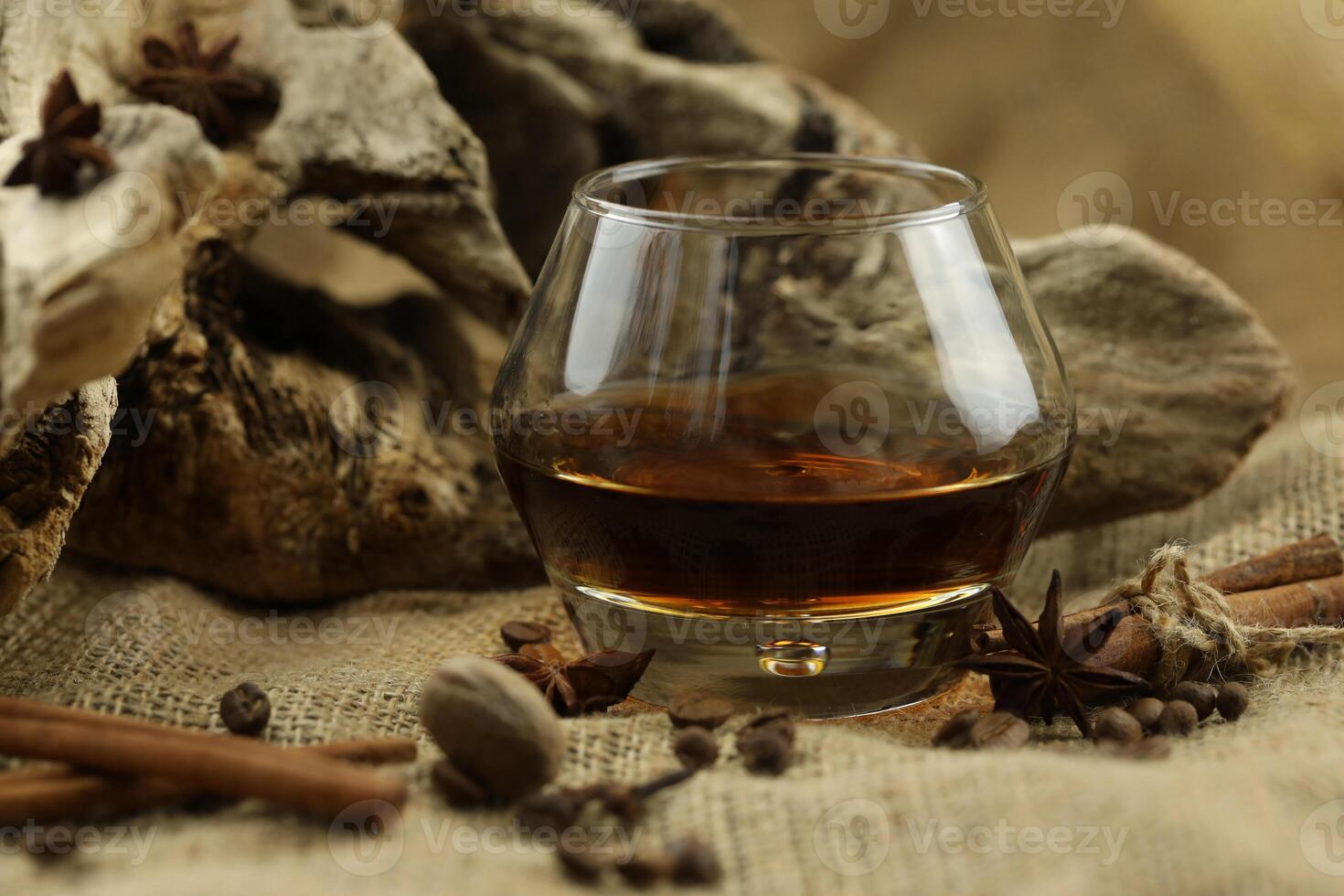 Glass of cognac with spice. Cloth background with copy space photo