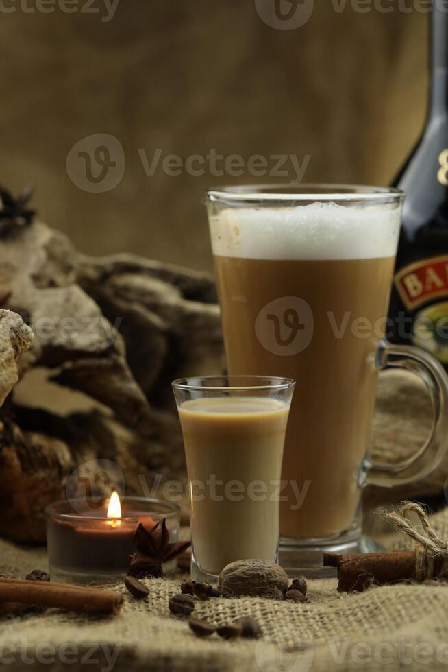 Glass coffee with glass of irish cream liqueur and spices. Cloth background with copy space photo