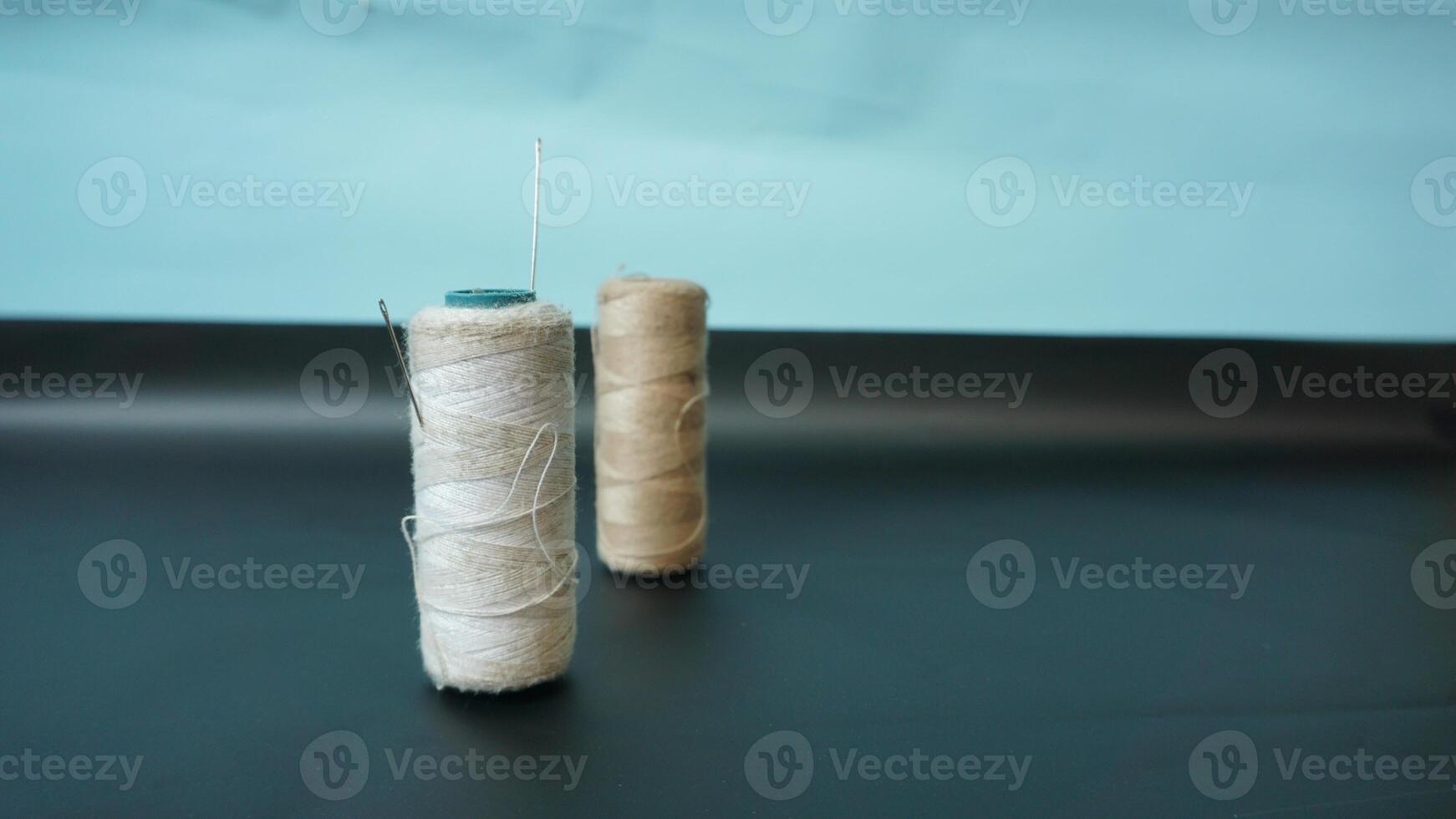 Spool of threads with needles on plain background. photo