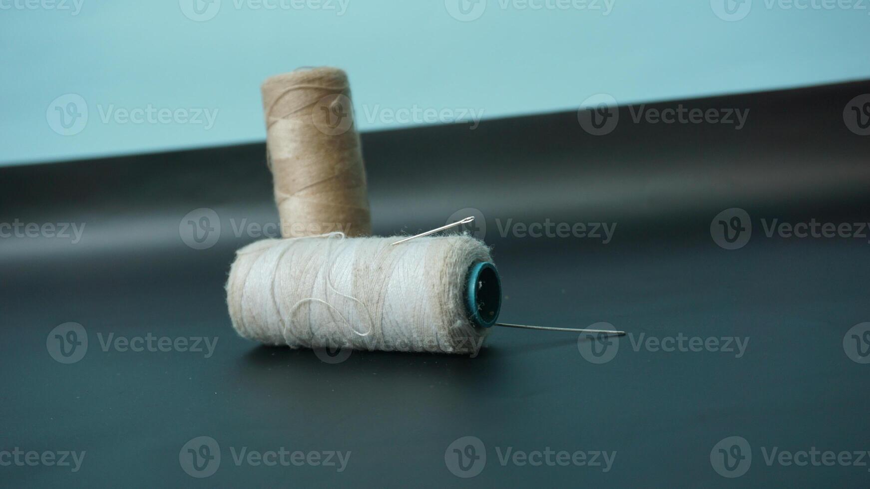 Spool of threads with needles on plain background. photo