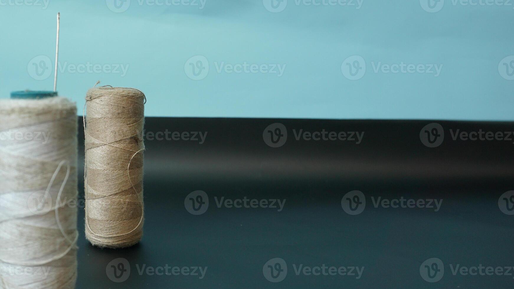 Spool of threads with needles on plain background. photo