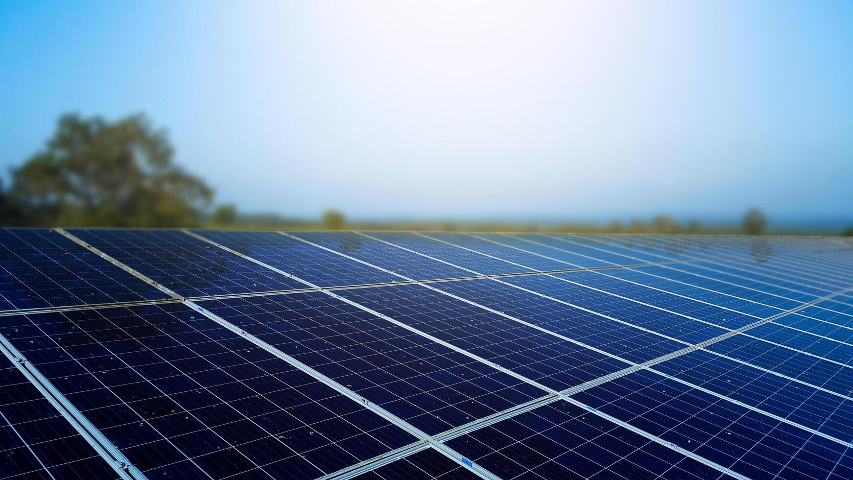 Dirty solar cell panels with blur mountains background photo