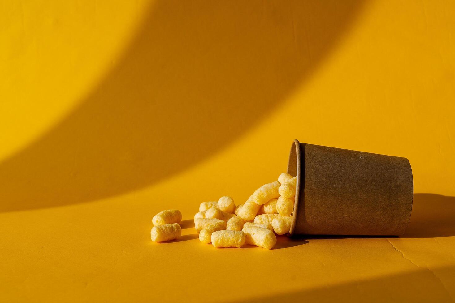 cans of paint on a colored background, shades of green, sweet corn lying in a can of paint, top view, minimalism concept, object on a yellow background close-up photo