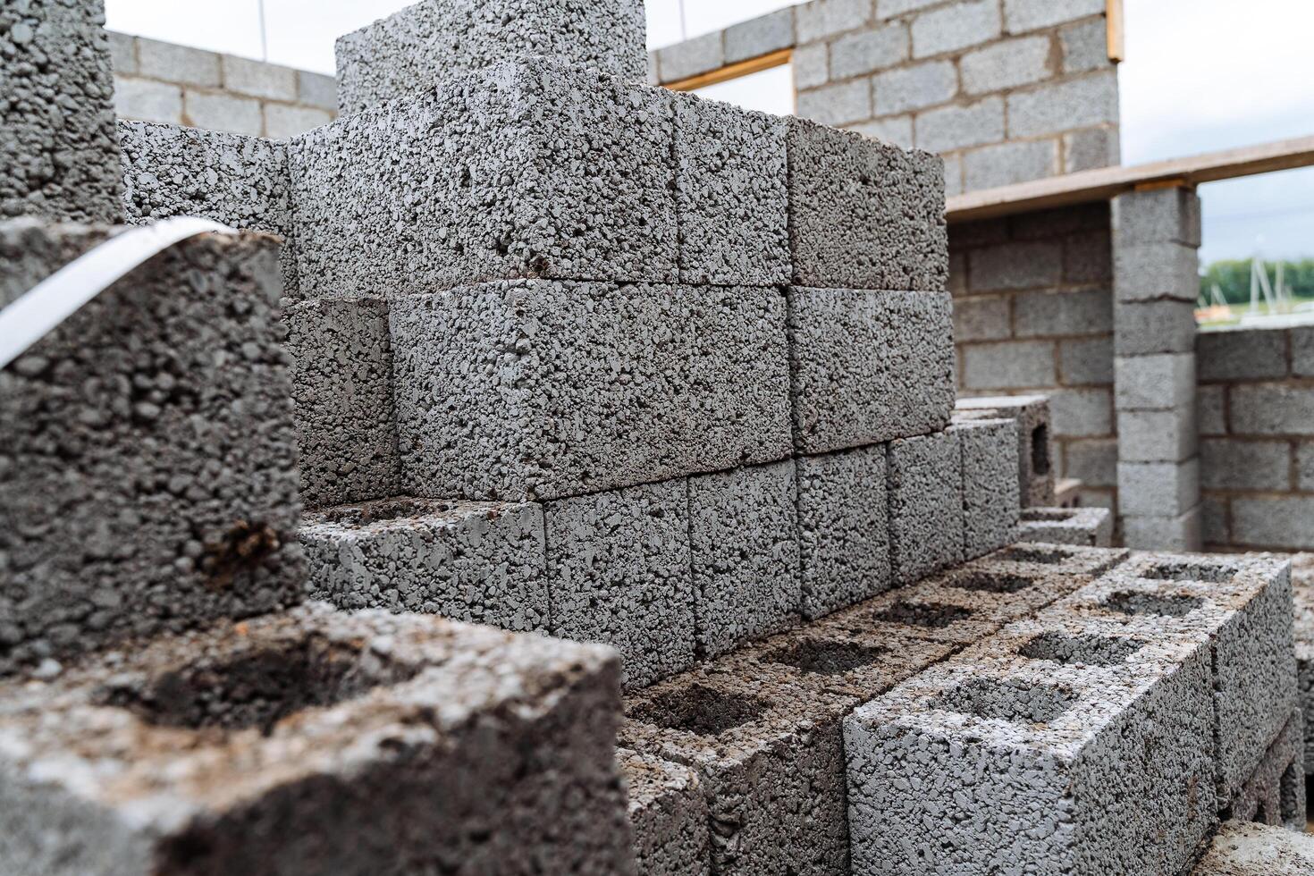 cinder blocks of gray concrete are neatly stacked in a pile, slender rows of bricks, material for building a house photo