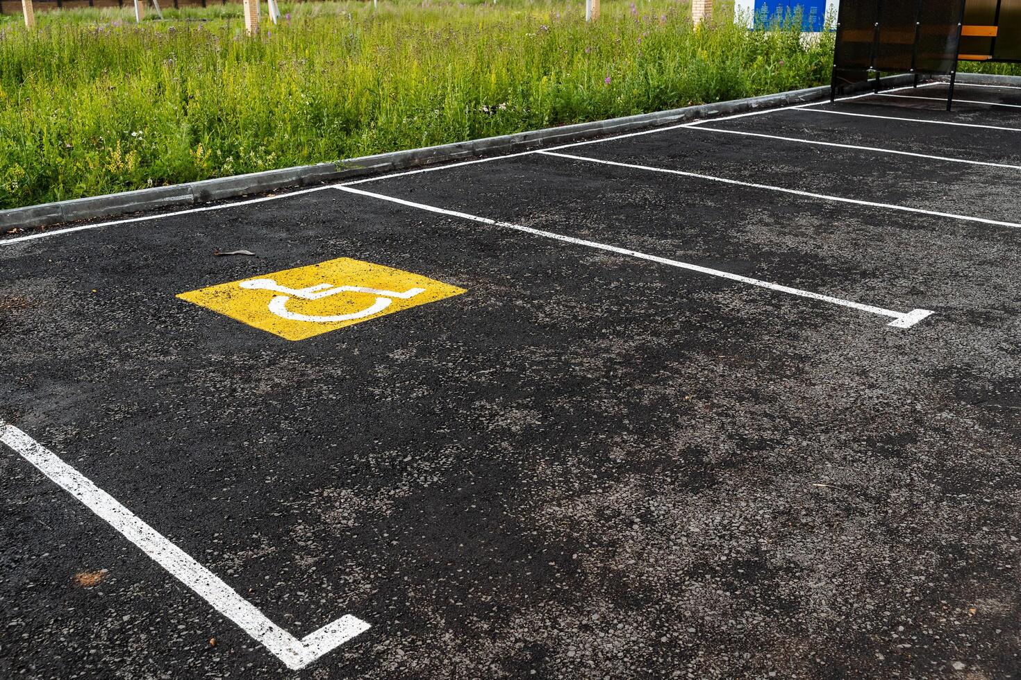 a yellow sign on the asphalt shows a Parking place for people with disabilities, for the disabled, a road sign, markings on the road photo