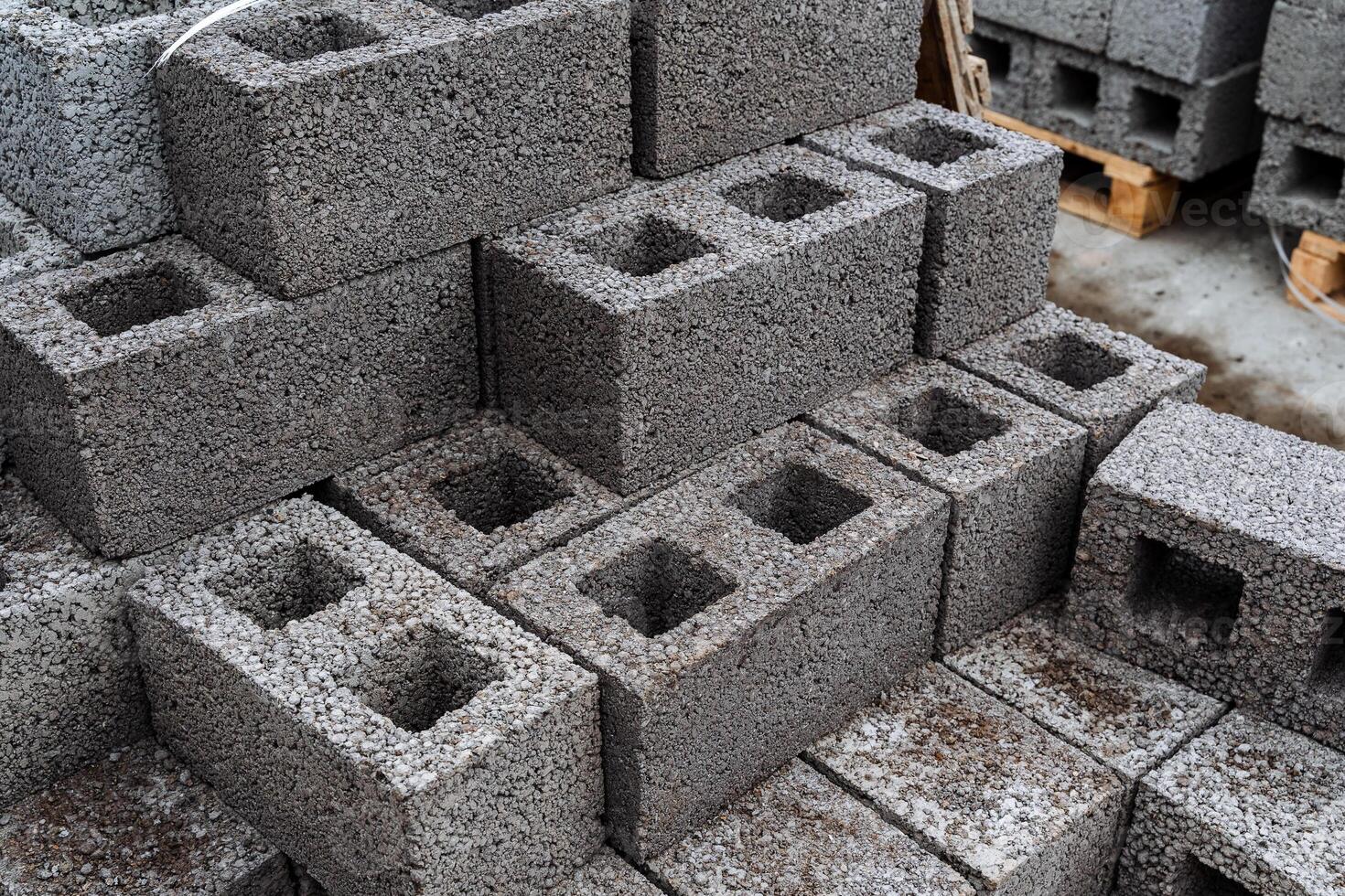 cinder blocks of gray concrete are neatly stacked in a pile, slender rows of bricks, material for building a house photo