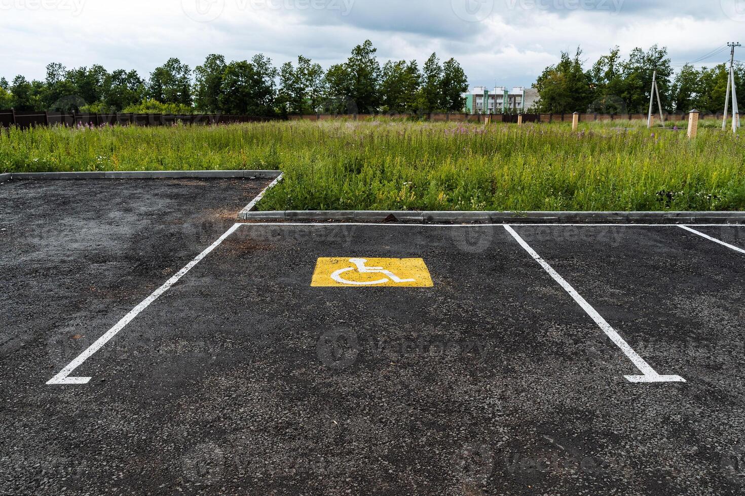 a yellow sign on the asphalt shows a Parking place for people with disabilities, for the disabled, a road sign, markings on the road photo