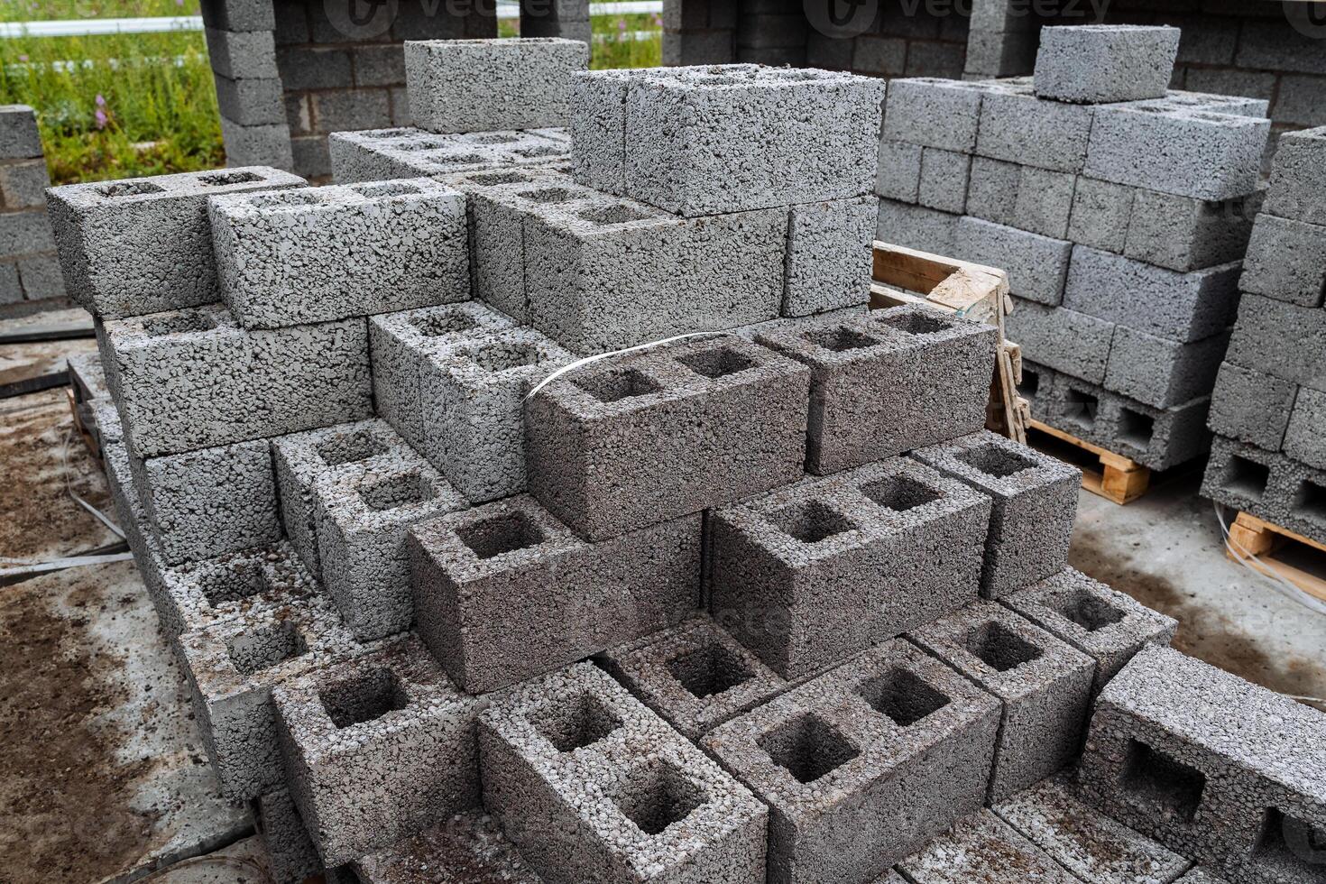 cinder blocks of gray concrete are neatly stacked in a pile, slender rows of bricks, material for building a house photo