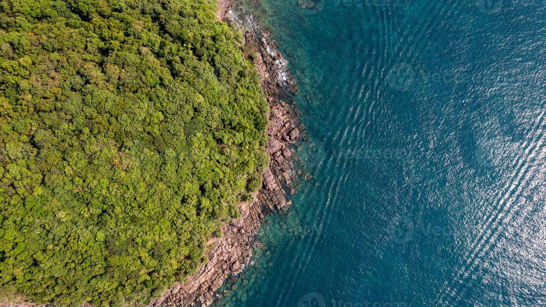 Verdant Coastline Meets Tranquil Azure Sea photo