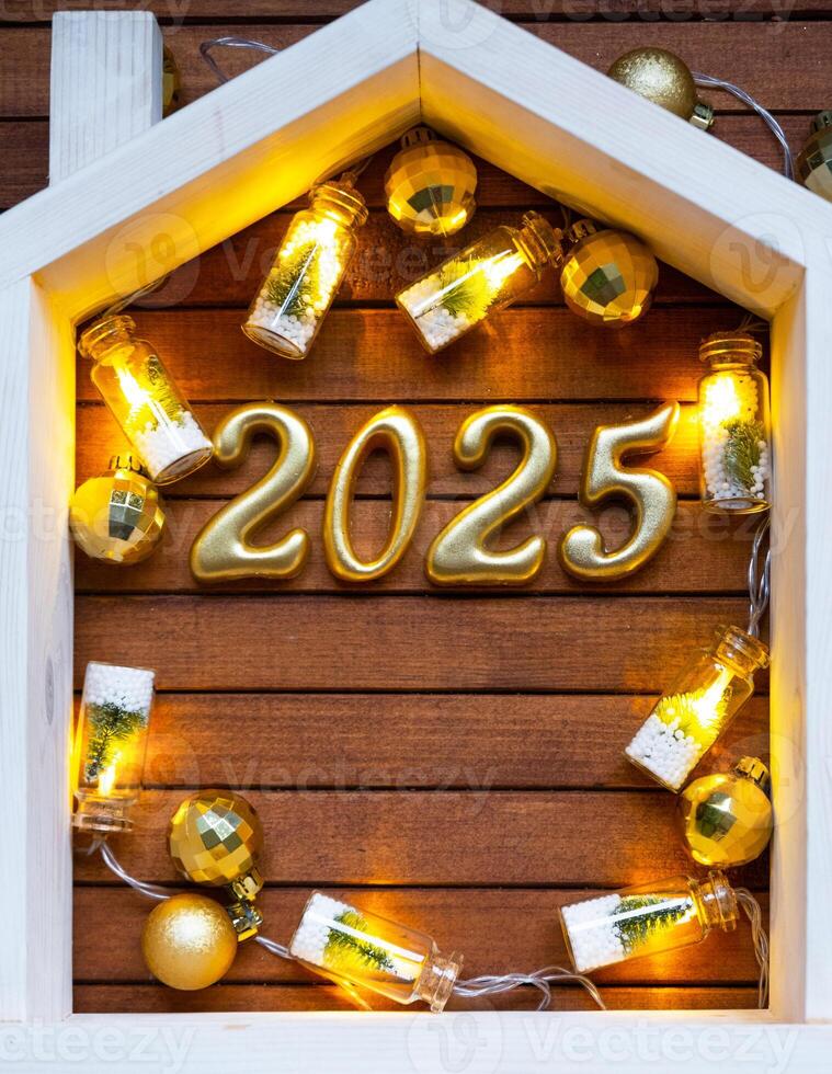 New Year 2025 golden letters under roof house. Calendar, greeting card. Purchase, construction, relocation, mortgage, insurance photo