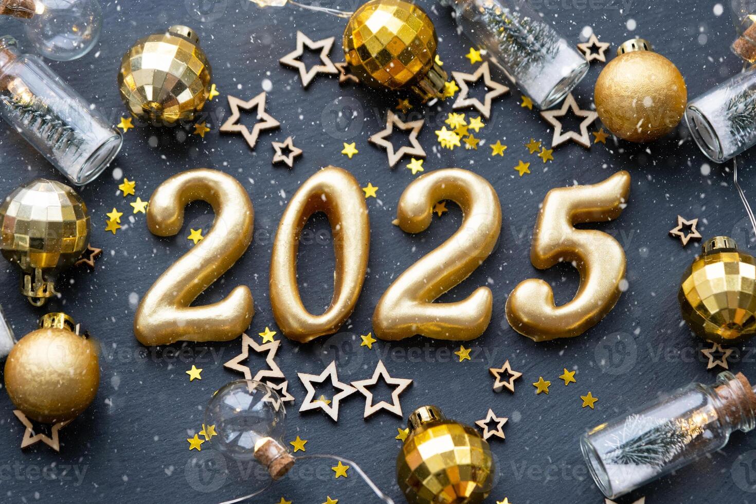 The golden figures 2025 made of candles on a black stone slate background are decorated with a festive decor of stars, sequins, fir branches, balls and garlands. Greeting card, happy New Year. photo