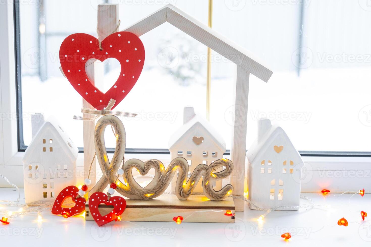 Key to tiny house of cozy home with Valentine decor on the windowsill. Gift for valentines day, family love nest. design, project, moving to new house, mortgage, rent and purchase real estate photo