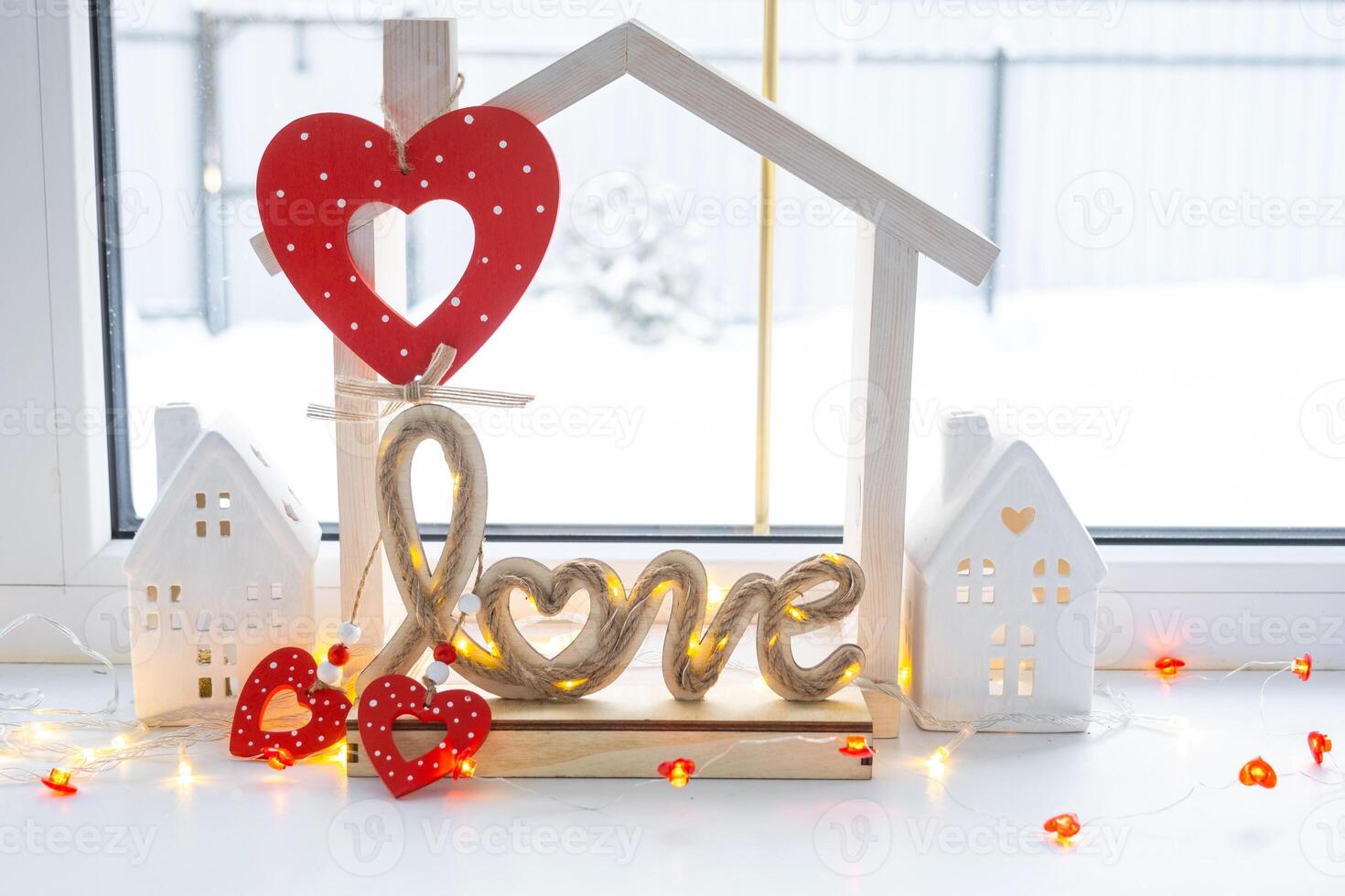 Key to tiny house of cozy home with Valentine decor on the windowsill. Gift for valentines day, family love nest. design, project, moving to new house, mortgage, rent and purchase real estate photo
