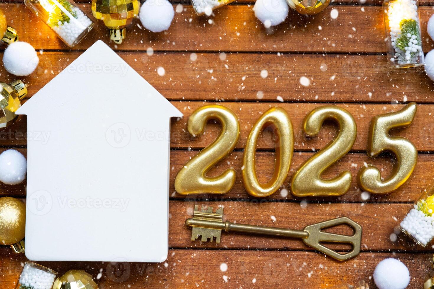 House key with tiny figure of home mock up on festive brown wooden background, lights of garlands. New Year 2025 wooden letters, greeting card. Purchase, construction, relocation, mortgage, insurance photo