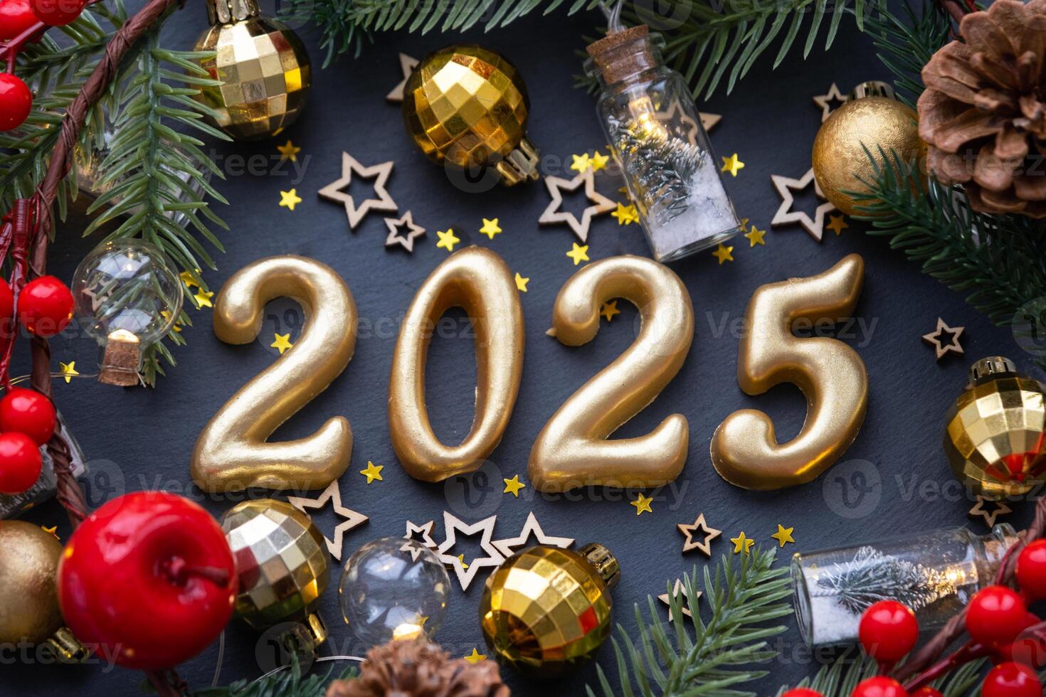 The golden figures 2025 made of candles on a black stone slate background are decorated with a festive decor of stars, sequins, fir branches, balls and garlands. Greeting card, happy New Year. photo