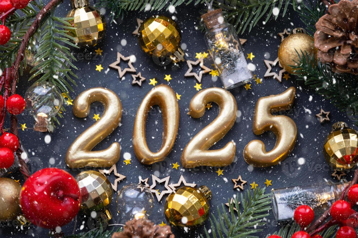 The golden figures 2025 made of candles on a black stone slate background are decorated with a festive decor of stars, sequins, fir branches, balls and garlands. Greeting card, happy New Year. photo