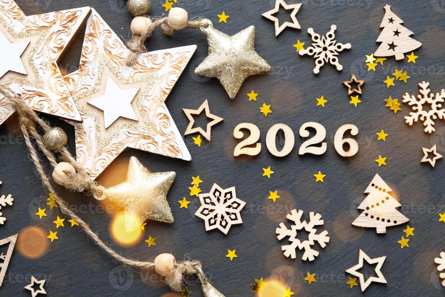 Happy New Year-wooden letters and the numbers 2026 on festive black background with sequins, stars, snow. Greetings, postcard. Calendar, cover photo