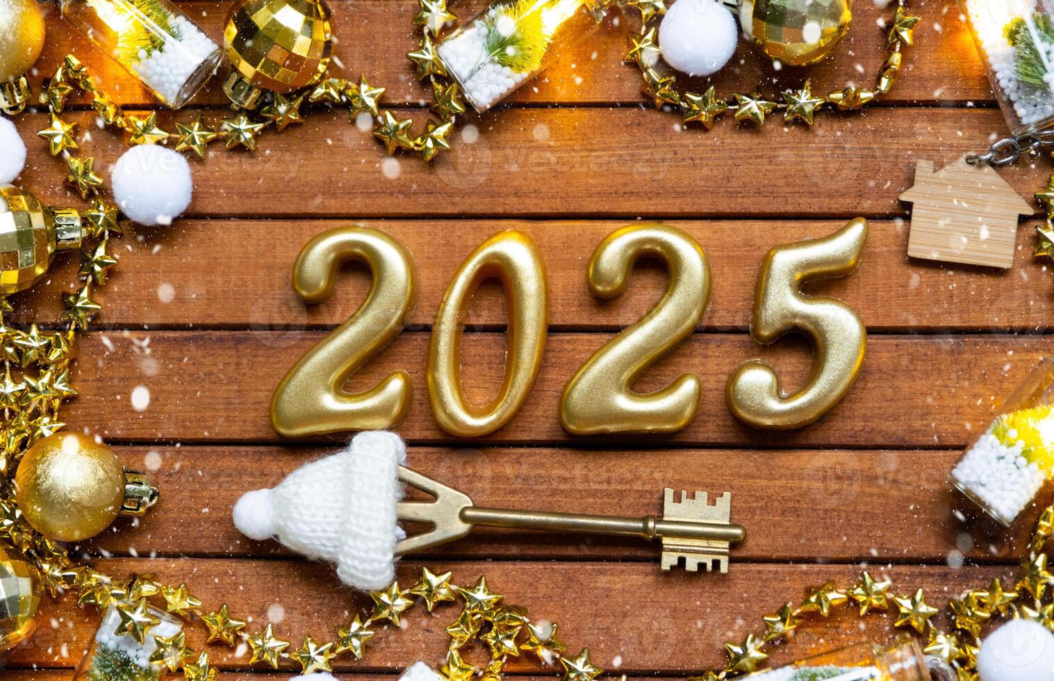 House key with tiny figure of home mock up on festive brown wooden background, lights of garlands. New Year 2025 wooden letters, greeting card. Purchase, construction, relocation, mortgage, insurance photo